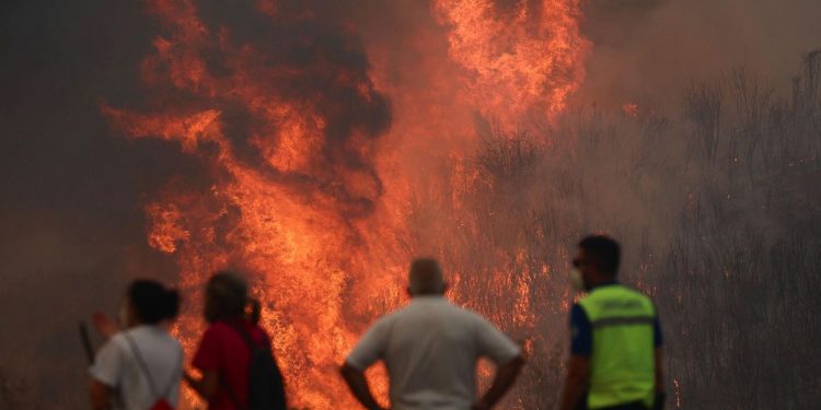 Varias personas luchan contra las llamas del incendio de A Gudiña (Ourense), este jueves. La DGT ha informado de que la circulación en la autovía A-52 está cortada entre los kilómetros 124 y 129 por los incendios forestales, concretamente en la zona de A Gudiña. La autovía está cortada en ese tramo en ambos sentidos y también está afectada la N-525 en los puntos kilométricos 129 y 86. EFE/ Sxenick