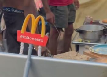 Los migrantes asentados en la playa del Trampolín crean su propio «McDonald’s» en un poblado improvisado